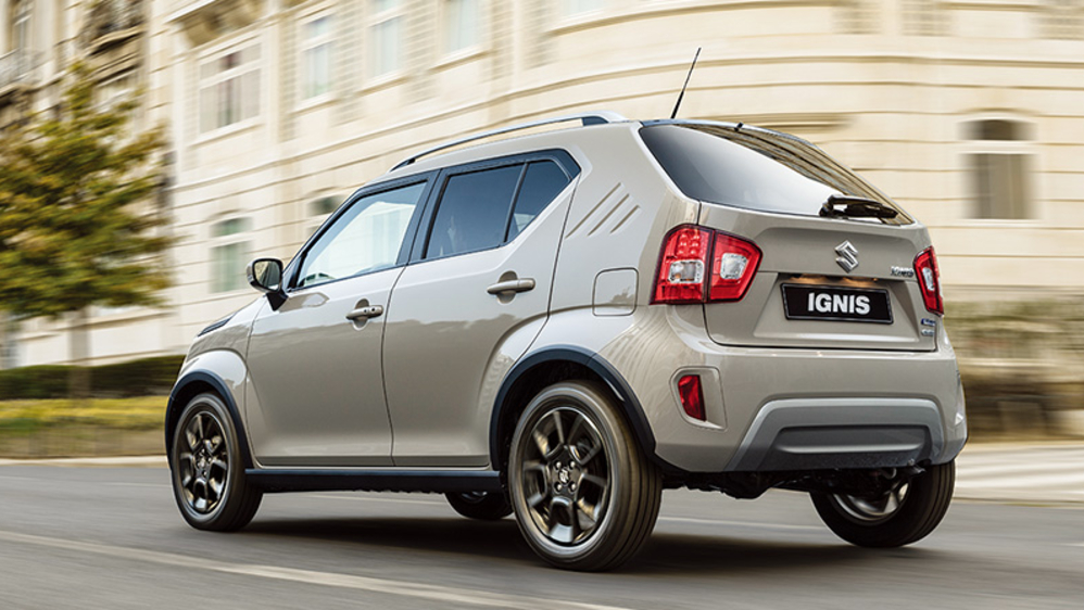 A light Suzuki Ignis driving down the road.